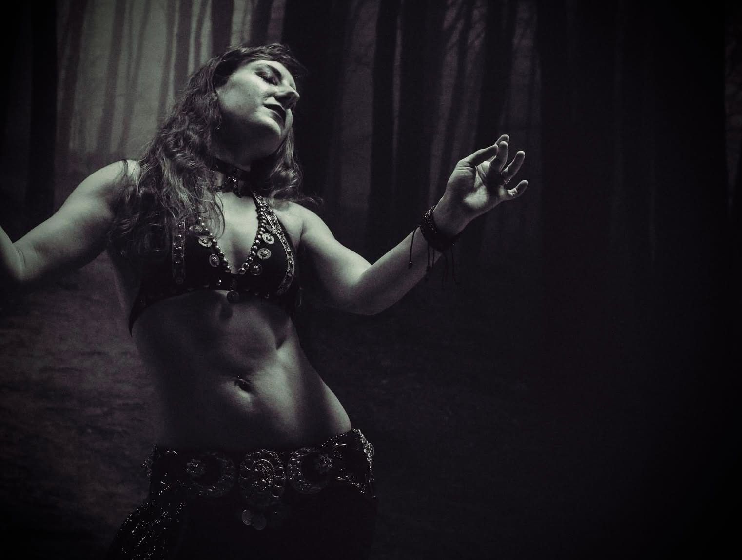 Black and white portrait of Amalphia Sylva, eyes closed, arms out